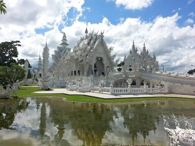 Chiang Rai: de witte tempel Wat Rong Khun met weerspiegeling in de vijver